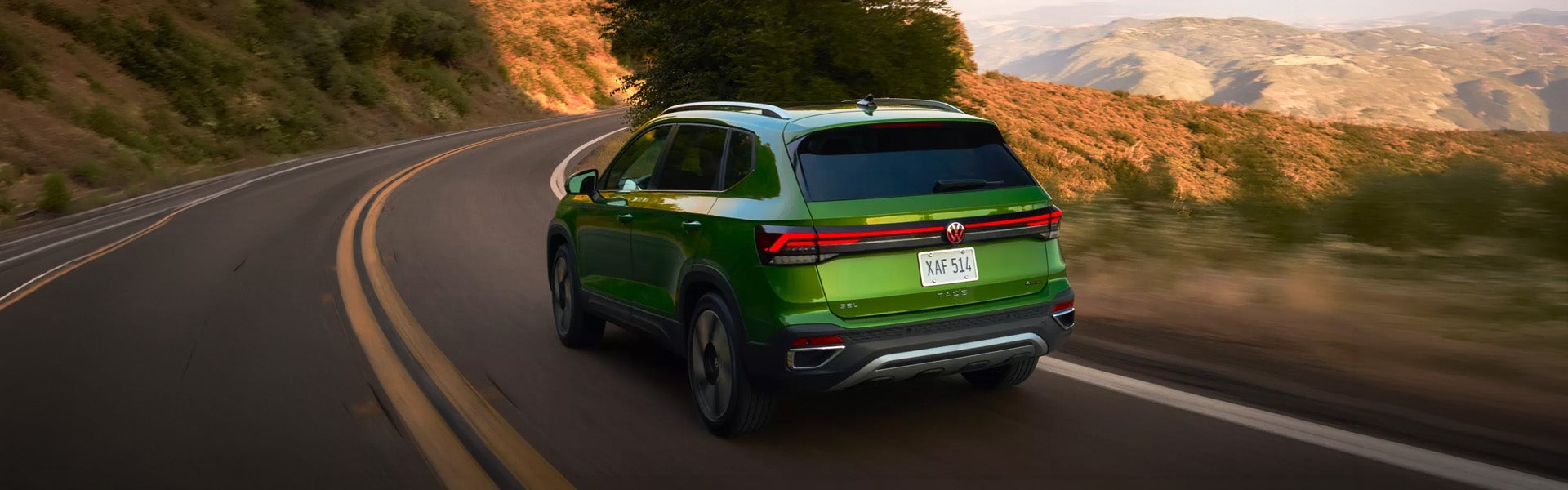 2026 Volkswagen Taos SUV driving on a winding road.